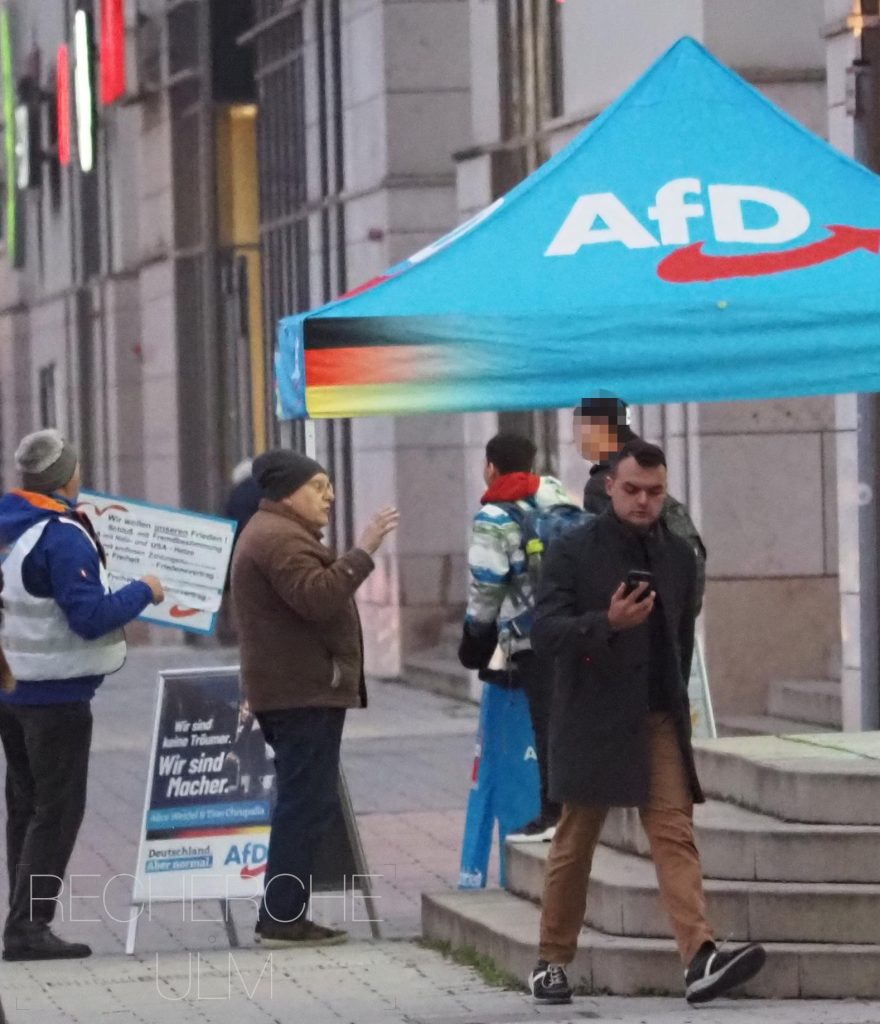 Franz Schmid bei einem Wahlkampfstand in Neu-Ulm, rechts mit Handy